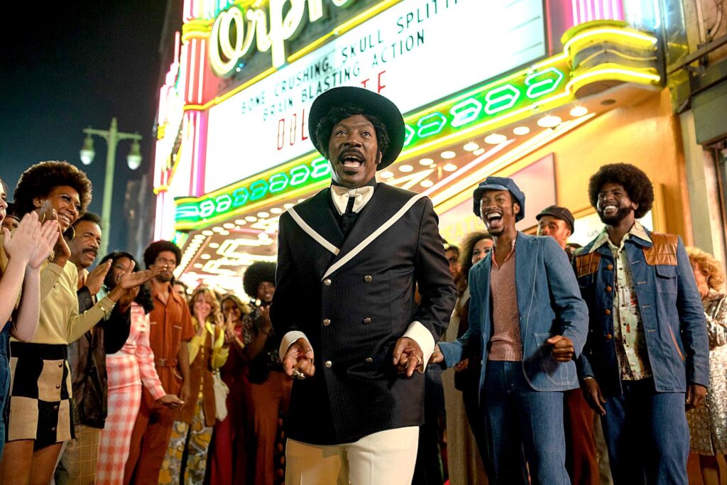 Dolemite movie still shot, man singing with crow in the background